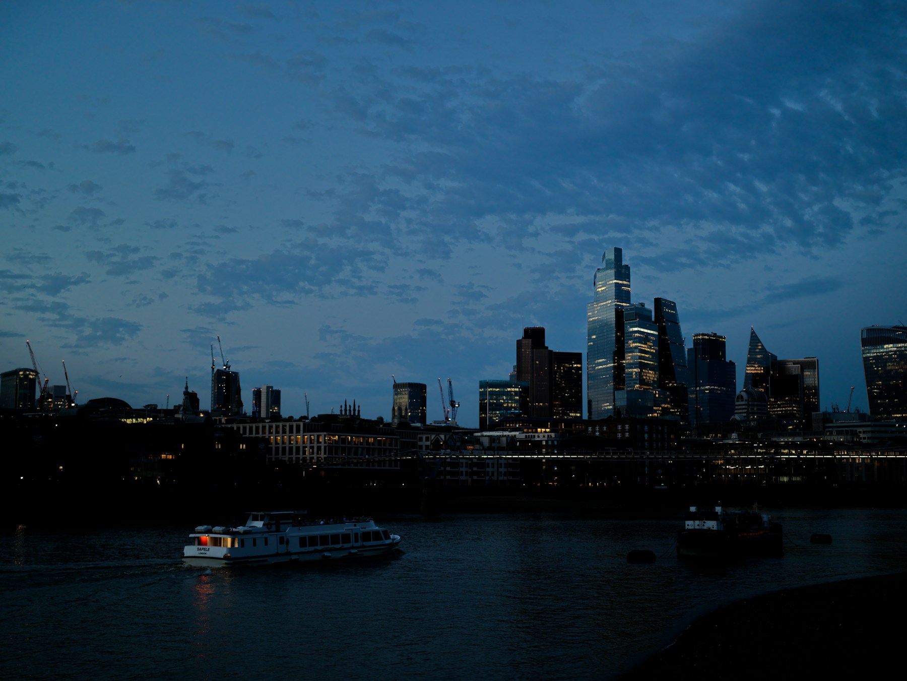 The City of London skyline at blue hour, viewed across the River Thames